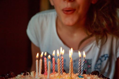 Person blowing out candles on a birthday cake.